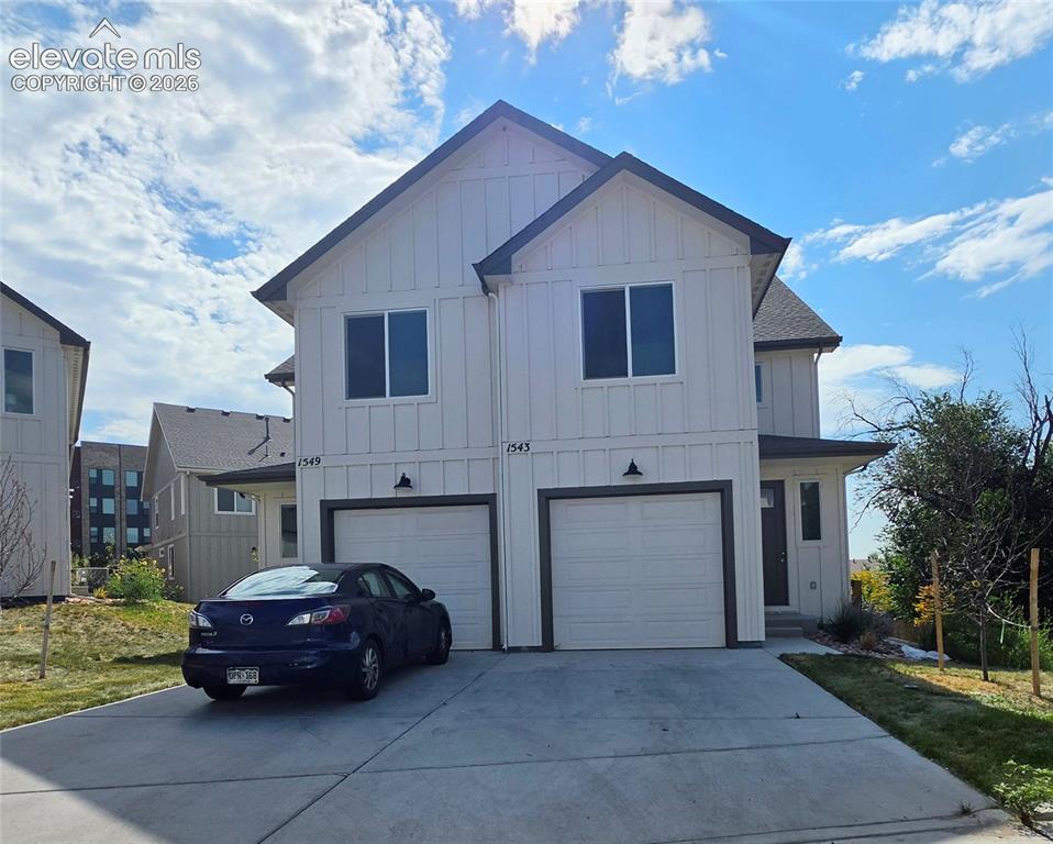 Caption: White vertical siding exterior, black trim, asphalt shingle roofing, attached garage, and concrete d