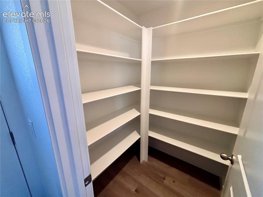 Image 10 of 23: Built-in shelving with multiple levels, white finishes, and wood-finish flo
