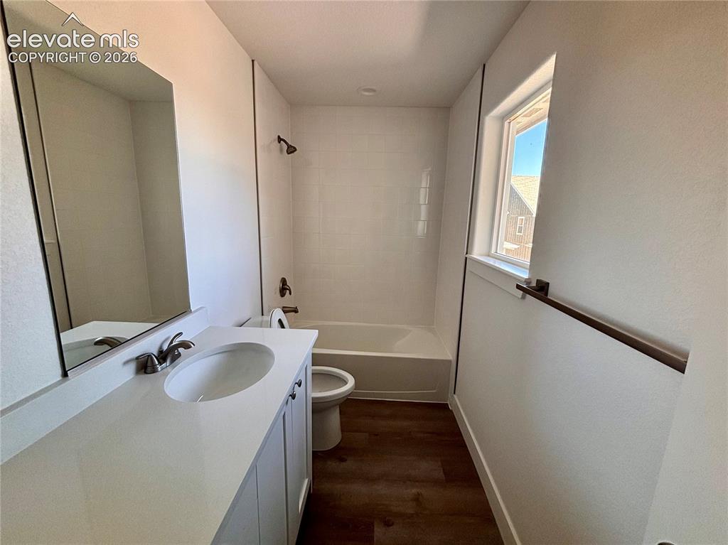 Image 14 of 23: Bathroom featuring a vanity with an integrated sink, a rectangular mirror, 