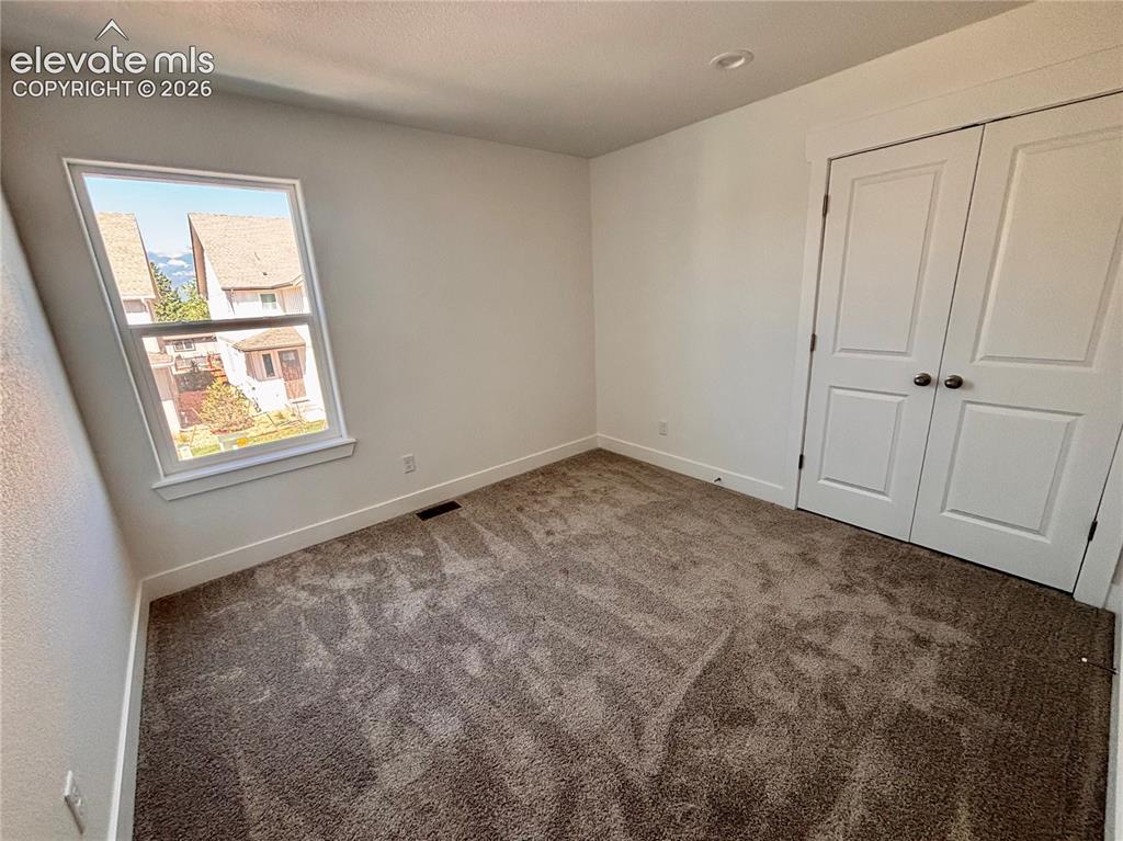 Image 15 of 23: Neutral-toned carpet flooring, white walls, and a window with white trim