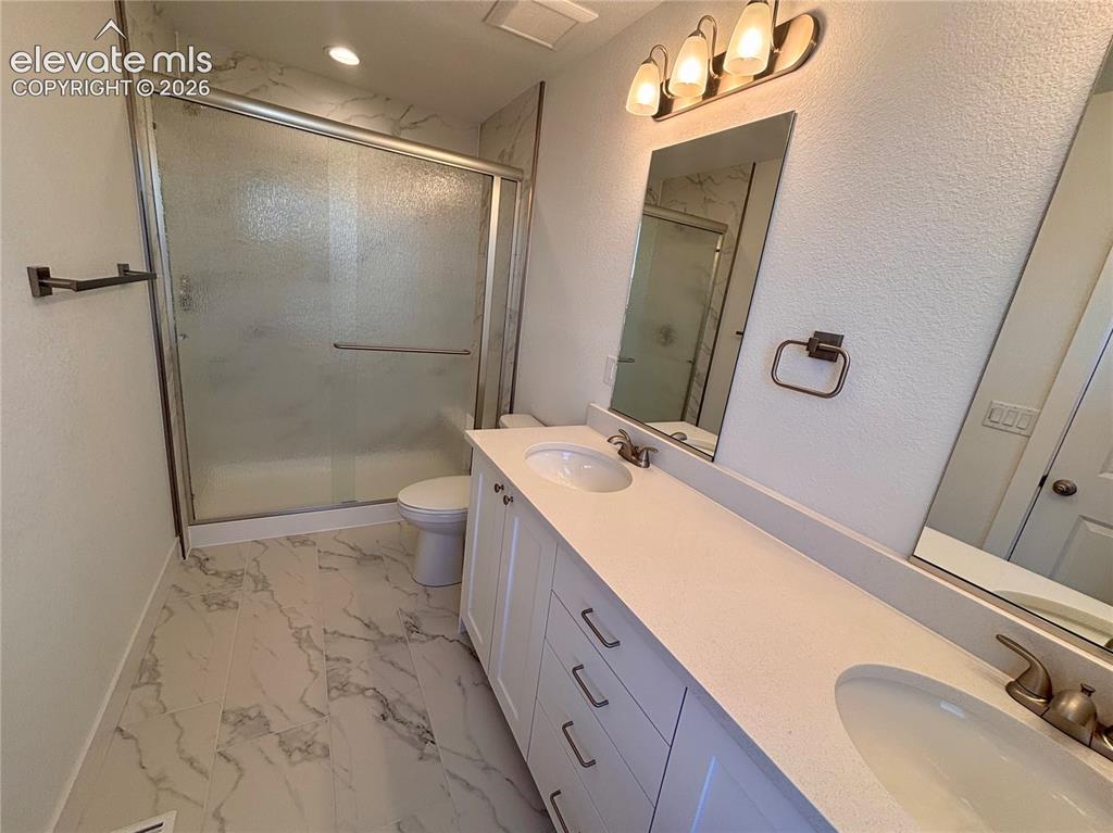 Image 20 of 23: Dual vanity with white cabinetry, solid surface countertop, and undermount 