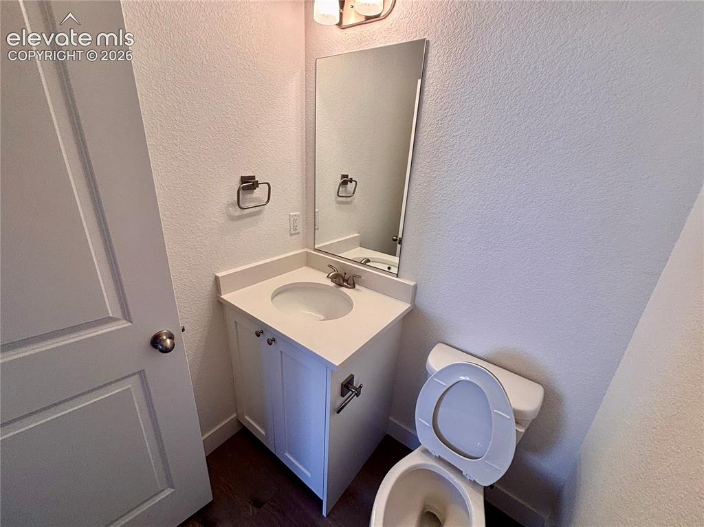 Image 9 of 23: White shaker vanity with integrated sink, rectangular mirror, and wood-fini