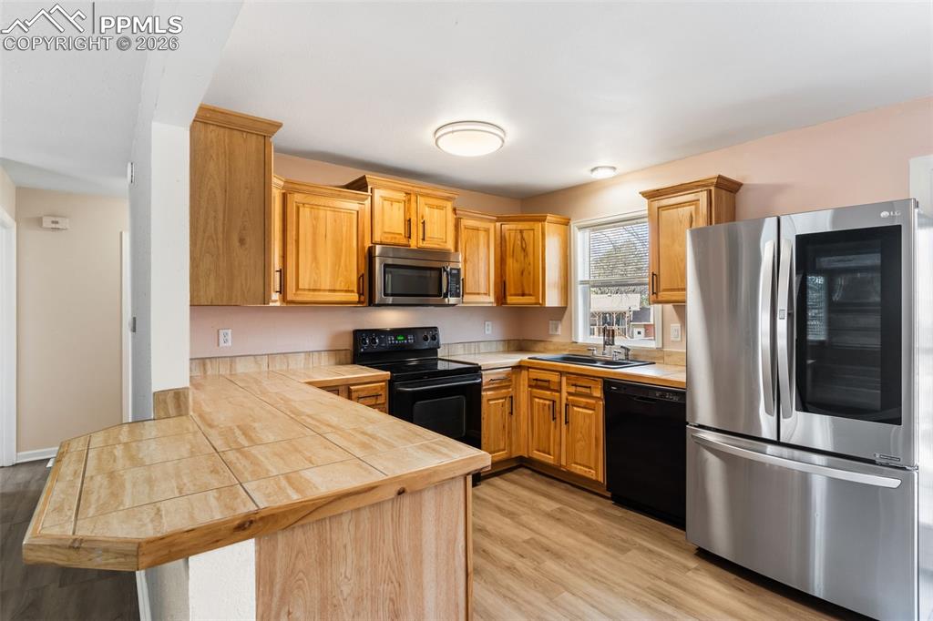 Image 10 of 35: Kitchen with stainless steel French door refrigerator