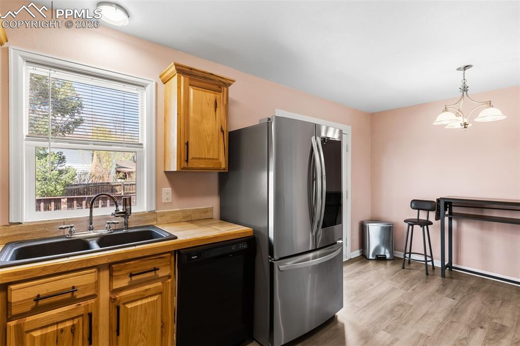 Image 11 of 35: Kitchen with hickory cabinets and tile countertops