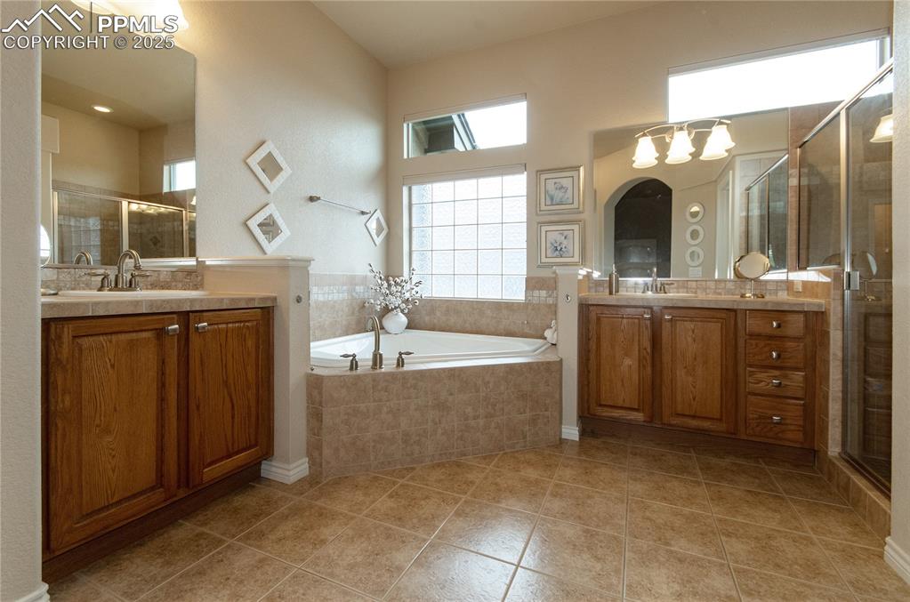 Image 22 of 43: En-suite bathroom offers tile floors, jetted tub, separate vanities and wal