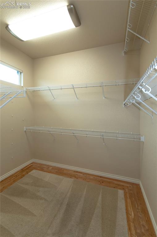 Image 24 of 43: Organized walk-in primary closet with cedar flooring.