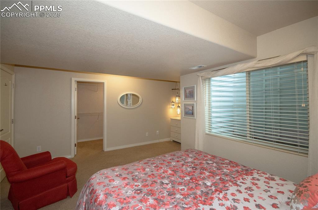 Image 32 of 43: Large window lets in natural light, spacious walk-in closet to keep belongi