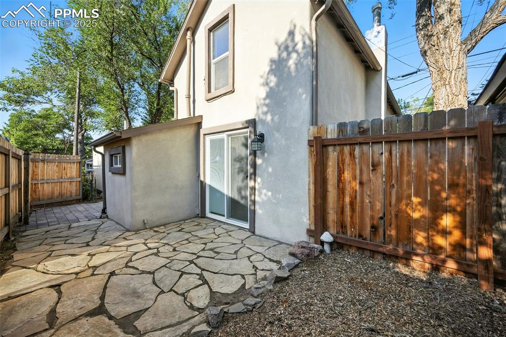 Image 6 of 25: Back of property with stucco siding and a patio