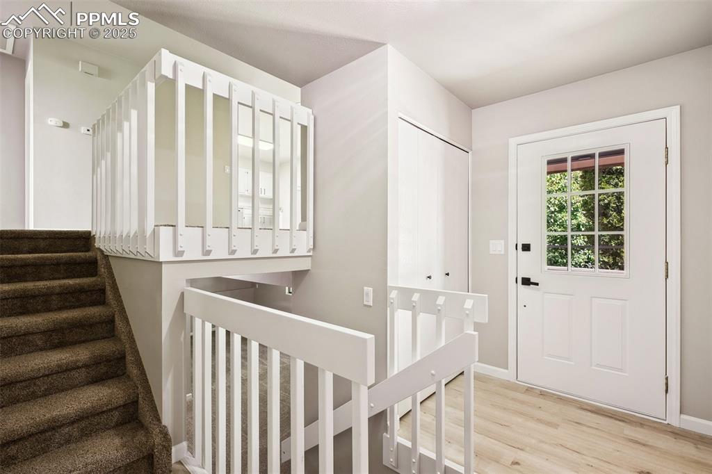 Image 3 of 29: Foyer entrance with light wood finished floors, stairway, and baseboards