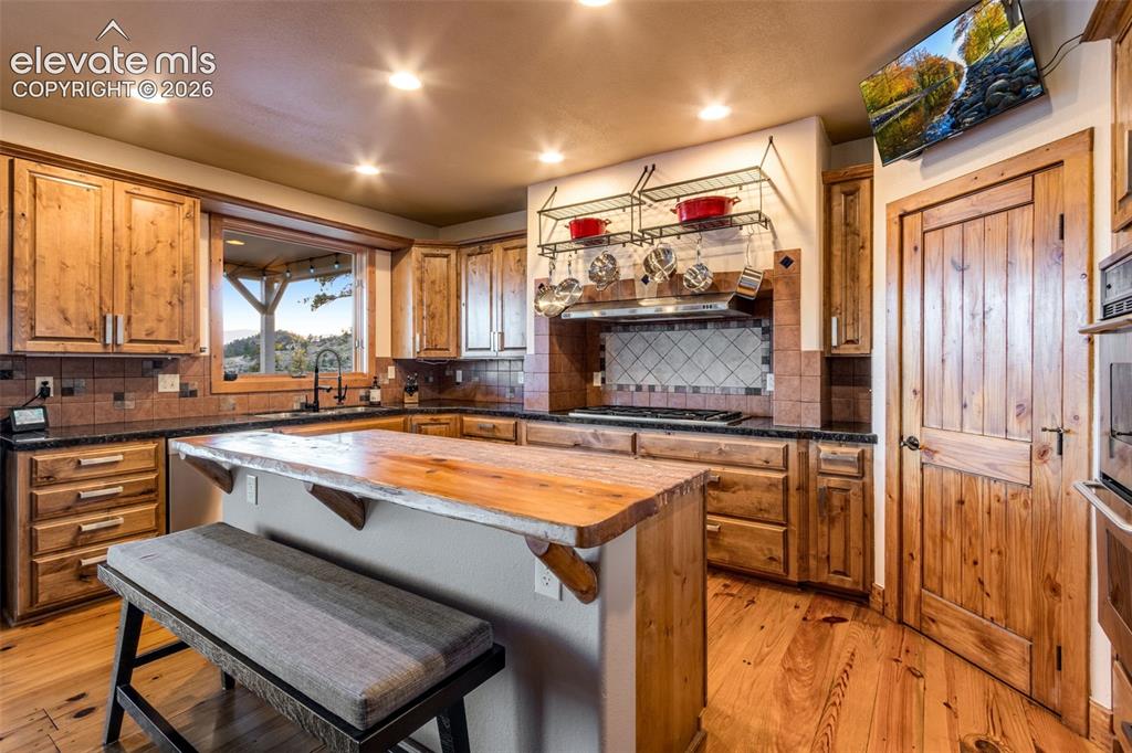 Image 21 of 50: Open kitchen featuring a center island, breakfast bar, pantry with built in