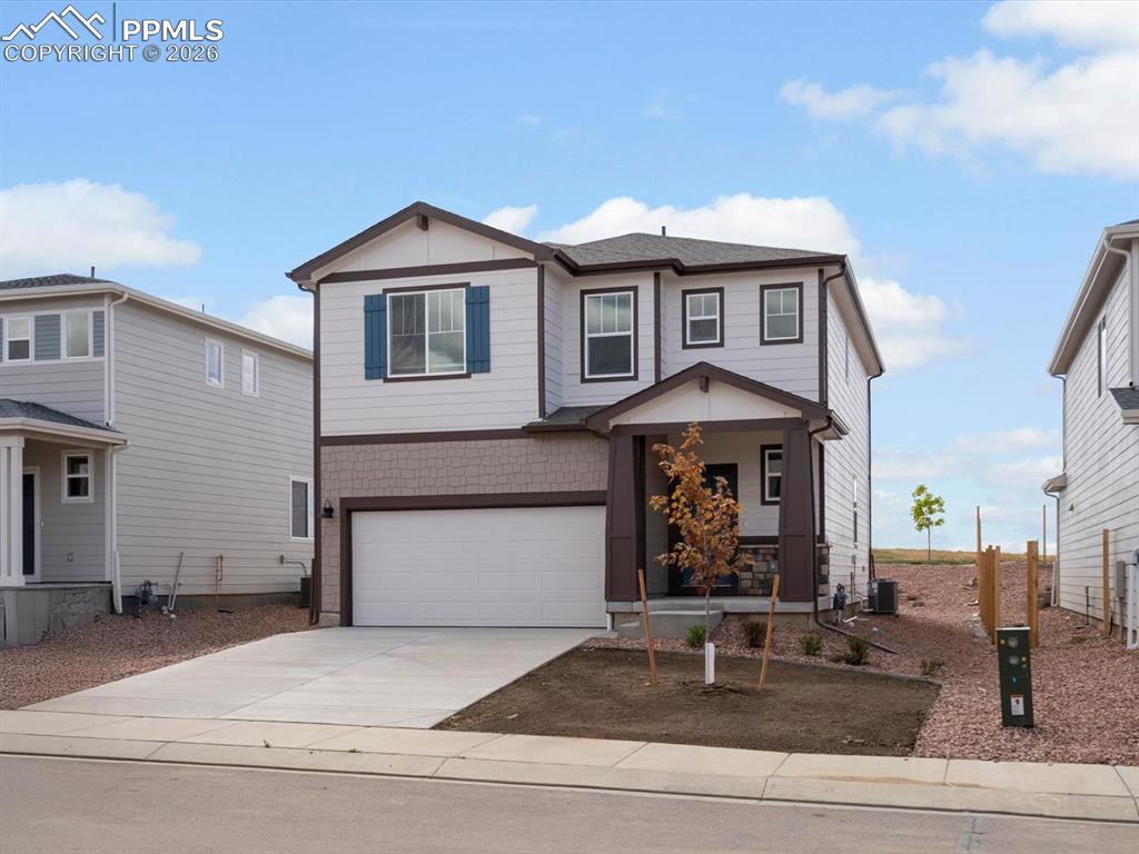 Image 1 of 16: View of front of property featuring driveway, a garage, and a porch