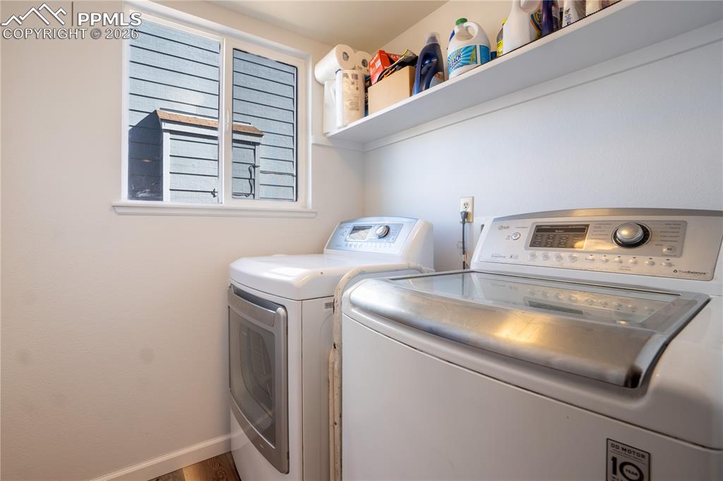 Image 15 of 40: Laundry area with separate washer and dryer and baseboards