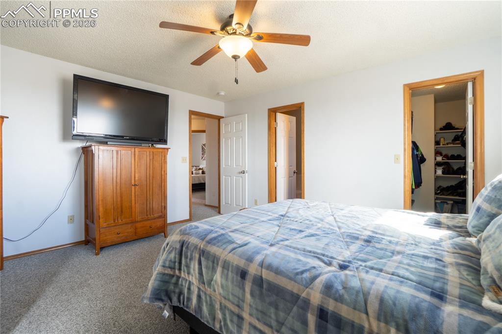 Image 17 of 40: Bedroom with carpet floors, ceiling fan, a textured ceiling, and a spacious