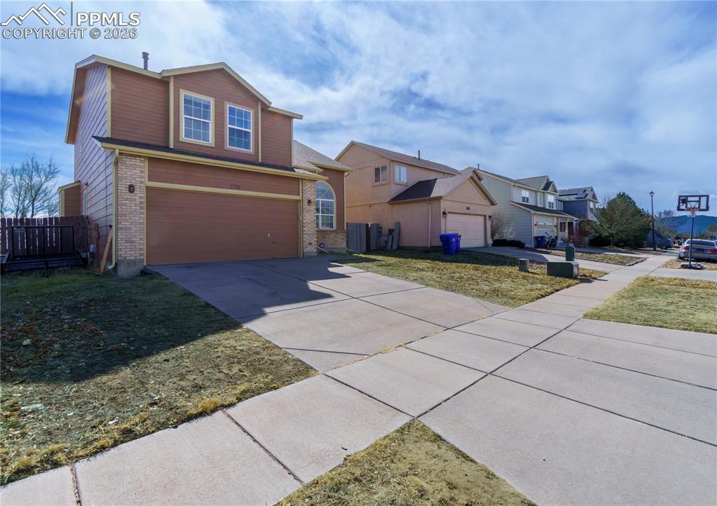 Image 2 of 40: Traditional-style house featuring concrete driveway, a garage, brick siding