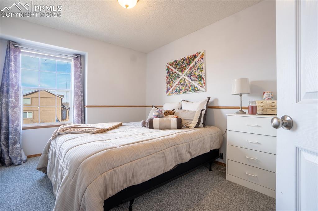 Image 24 of 40: Carpeted bedroom featuring a textured ceiling