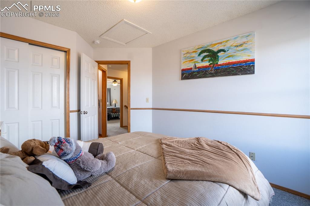 Image 25 of 40: Bedroom with carpet floors, a closet, and a textured ceiling