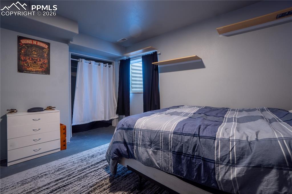 Image 34 of 40: Bedroom with concrete floors