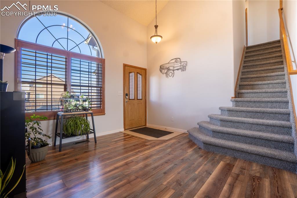 Image 6 of 40: Entrance foyer with vaulted ceiling and dark wood-style floors