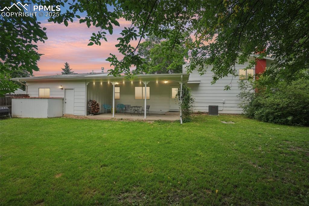 Image 3 of 49: Twilight picture of the backyard and covered patio!
