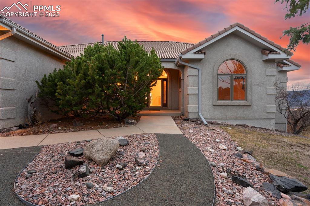 Image 2 of 48: View of front of house featuring a tile roof and stucco siding