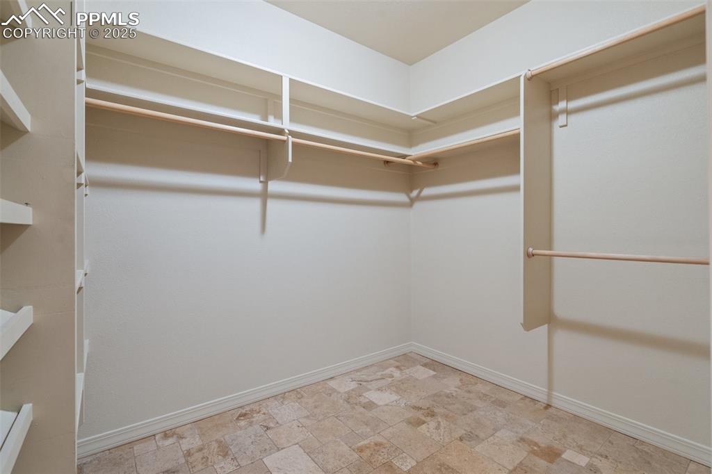 Image 34 of 48: Spacious closet with stone finish floor