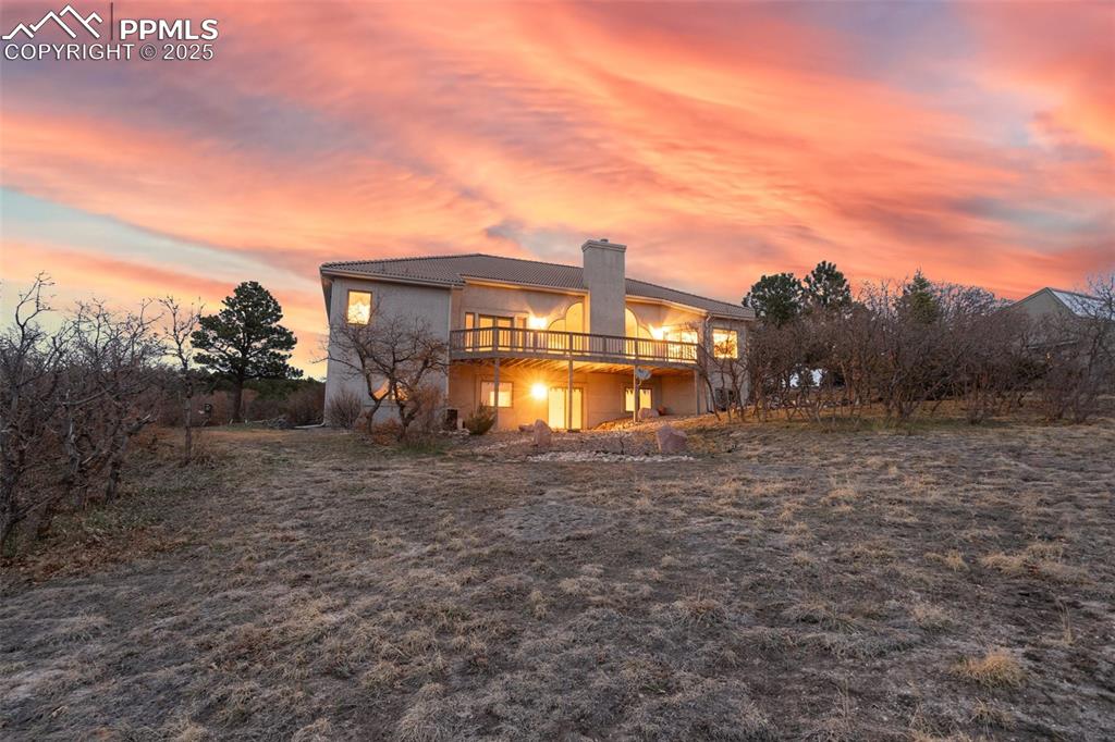 Image 44 of 48: Back of property with a chimney and stucco siding