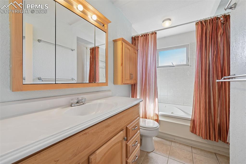 Image 10 of 25: Bathroom featuring vanity, a combined bath / shower with jetted tub, and li
