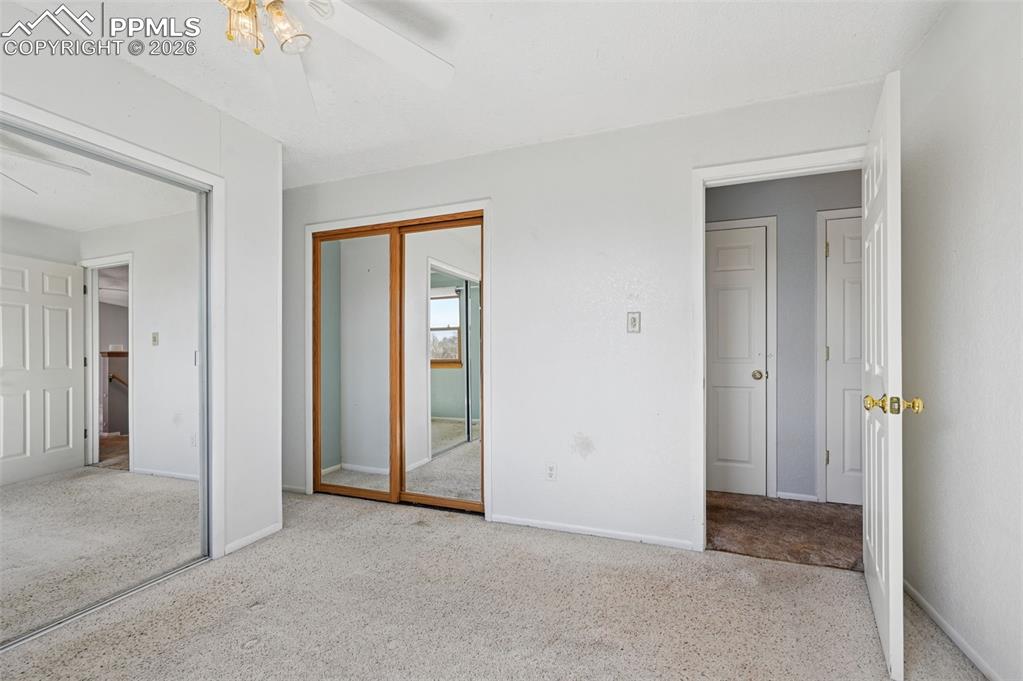 Image 12 of 25: Unfurnished bedroom featuring a closet, light carpet, and a ceiling fan