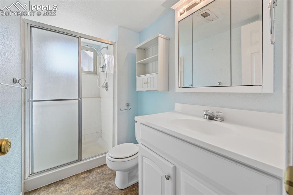 Image 21 of 25: Full bathroom with vanity and a stall shower