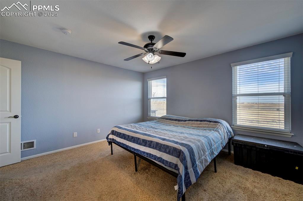 Image 18 of 45: Bedroom with carpet floors, ceiling fan, adjoining full bathroom, walk-in c