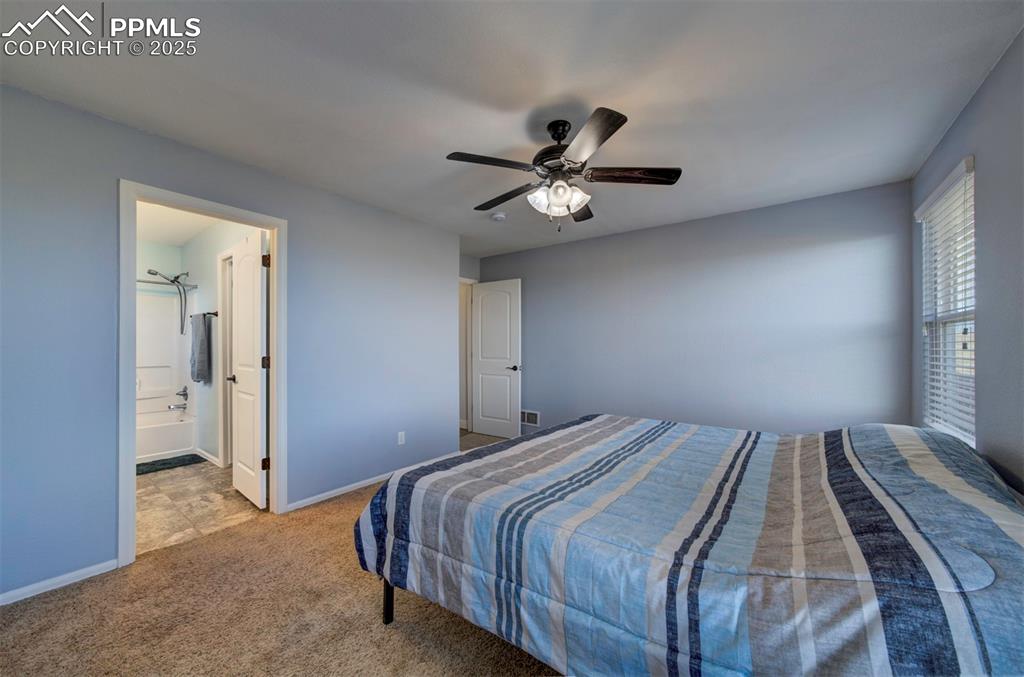 Image 19 of 45: Bedroom with carpet floors, ceiling fan, adjoining full bathroom, walk-in c
