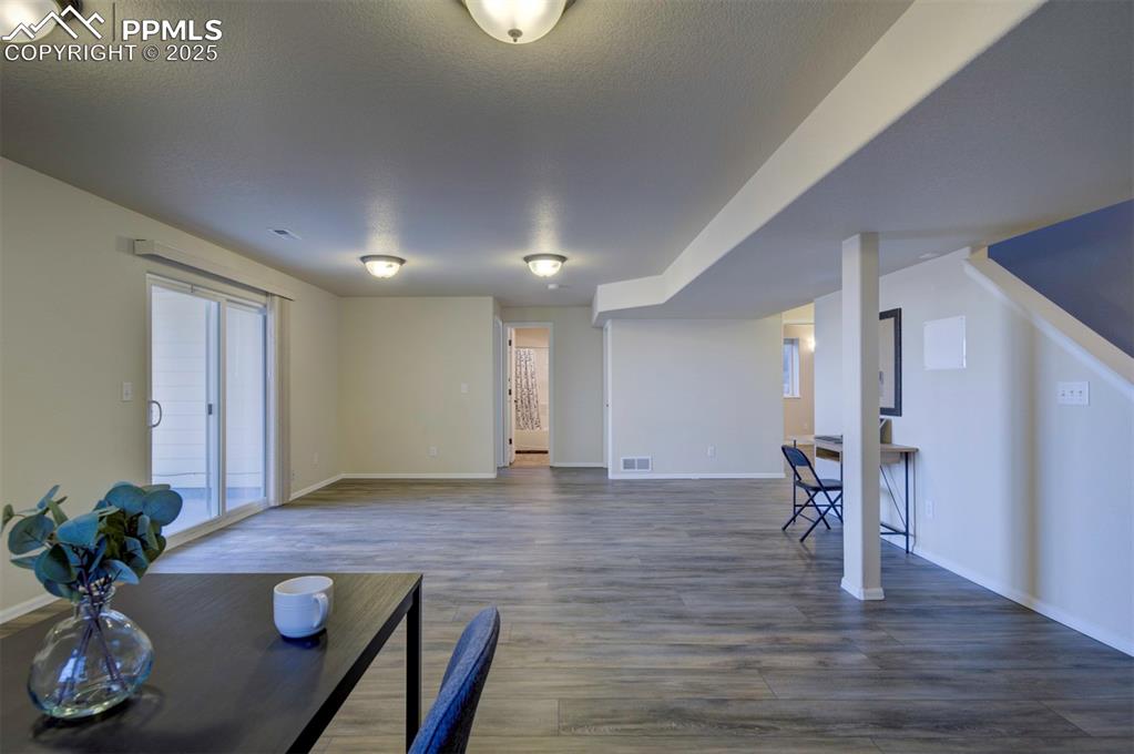 Image 26 of 45: Family room in basement w/ kitchenette/wet bar, sliding glass door to backy