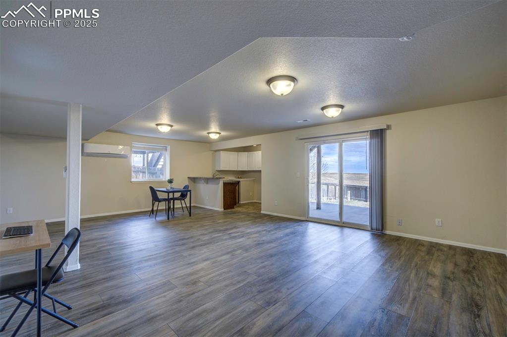Image 28 of 45: Family room in basement w/ kitchenette/wet bar, sliding glass door to backy