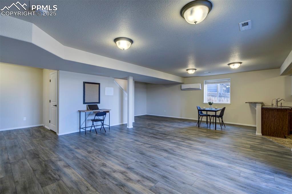 Image 29 of 45: Family room in basement w/ kitchenette/wet bar, sliding glass door to backy