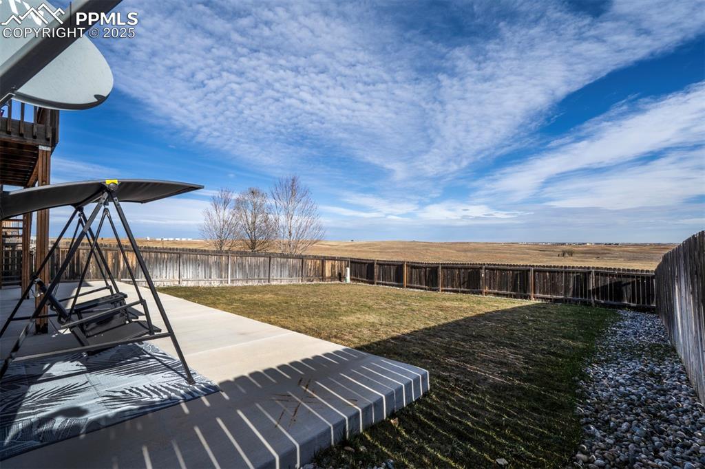 Image 39 of 45: Fenced backyard with a patio area