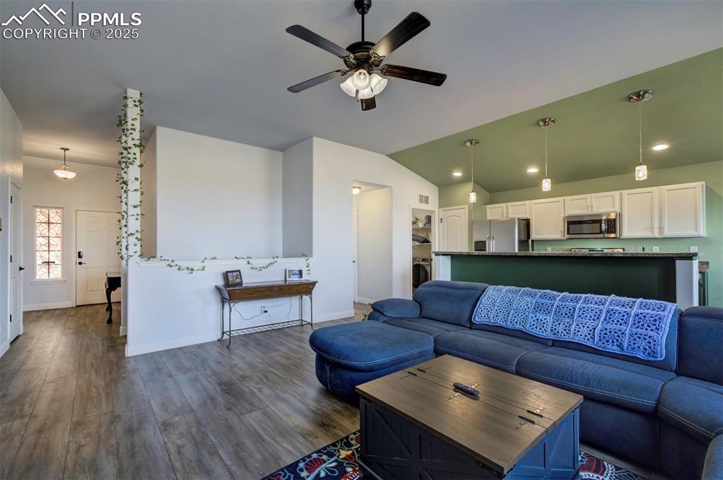 Image 6 of 45: Living area with luxury vinyl floors, lofted ceiling, and ceiling fan
