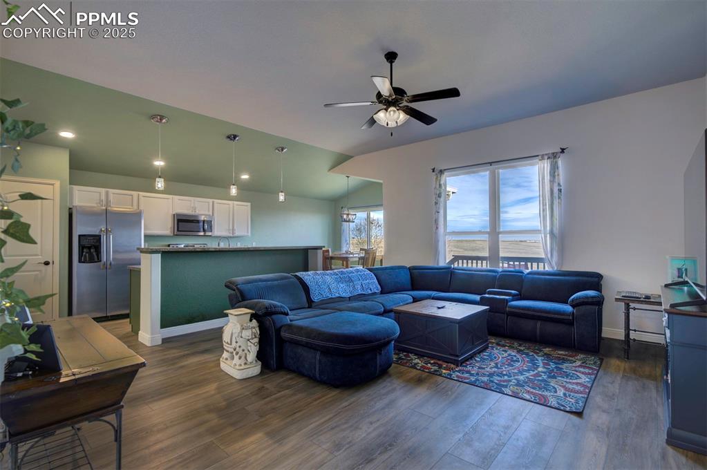 Image 7 of 45: Living area with luxury vinyl floors, lofted ceiling, and ceiling fan