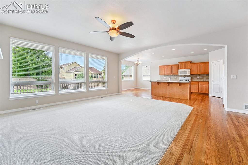 Image 18 of 46: View from main living space toward open kitchen/ dining with island