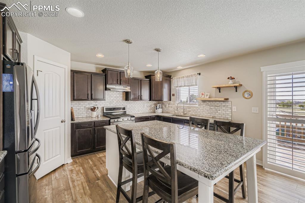 Image 10 of 42: Gourmet kitchen with granite countertops, decorative backsplash, gas burner