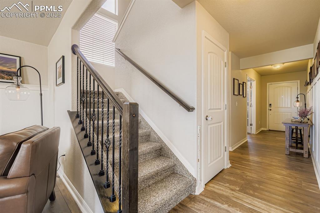 Image 14 of 42: Entry way. Well lit staircase to the upper level with wrought iron spindle