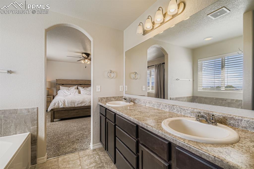 Image 18 of 42: Archway door leading into the primate 5-piece bath.