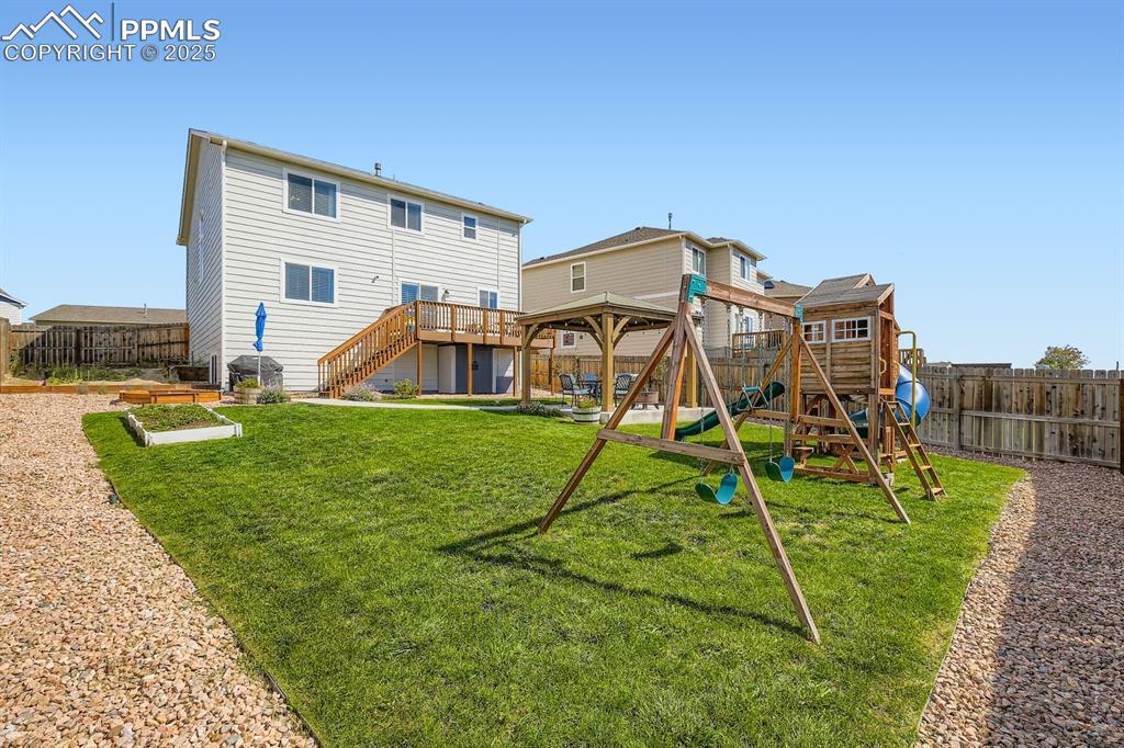 Image 29 of 42: Swing set, play set, shed under the deck and sand box are included.