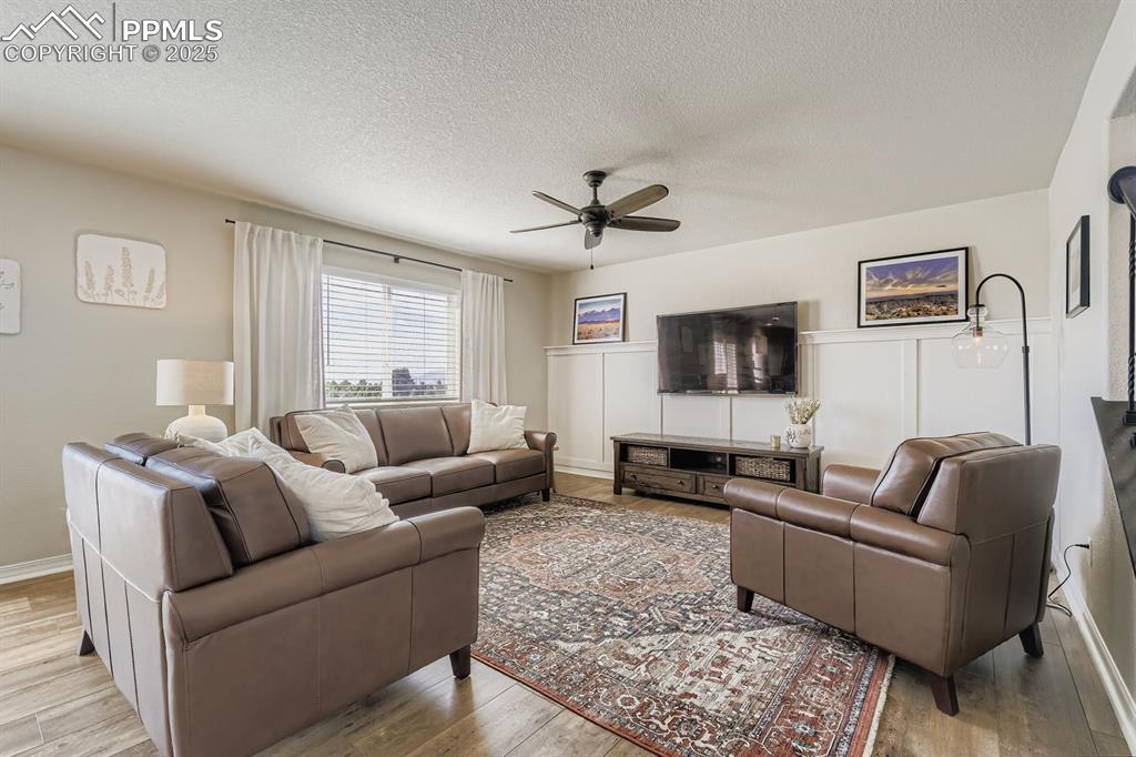 Image 6 of 42: Custom wainscot accent wall throughout. Living room large screen TV includ