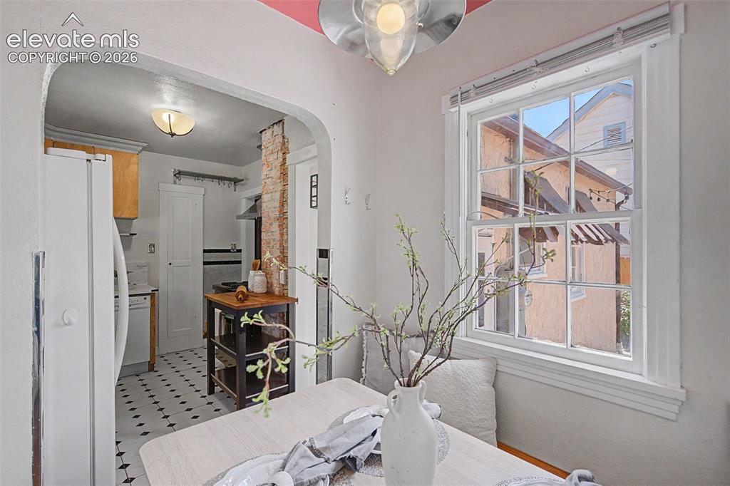 Image 15 of 37: Kitchen featuring black and white patterned tile flooring, wood-finish cabi