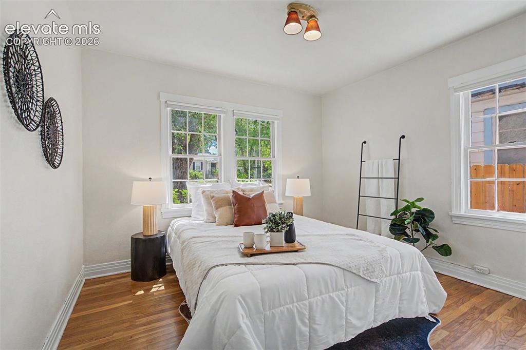 Image 17 of 37: Bedroom featuring wood-finish flooring, white baseboards, and bright white
