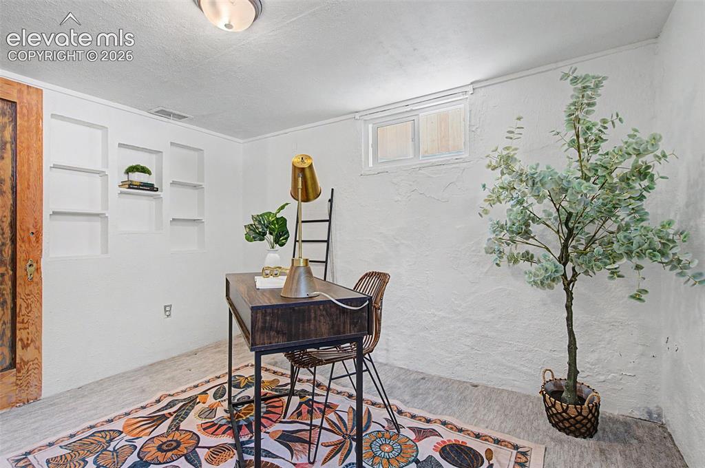 Image 28 of 37: Finished room featuring a ceiling-mounted light fixture, built-in wall shel
