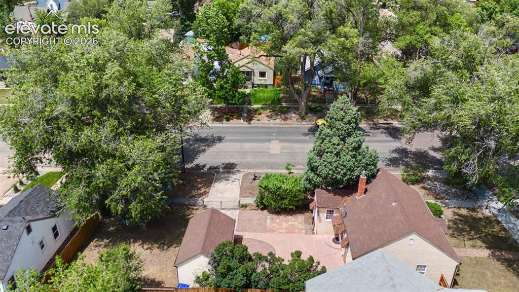 Image 35 of 37: Expansive paved patio area featuring a brick chimney and mature landscaping