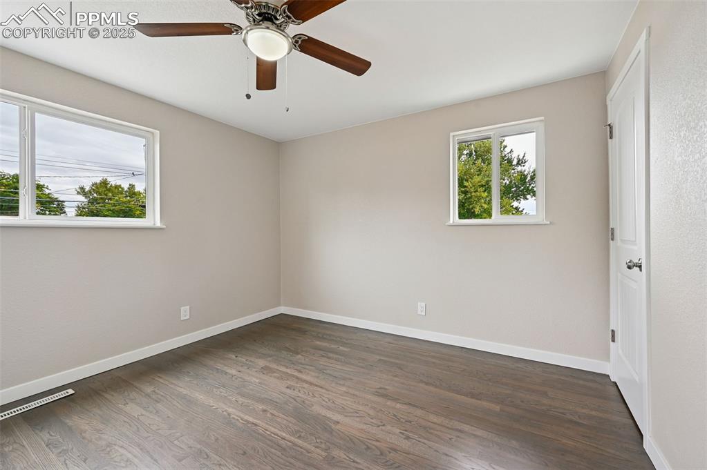 Image 13 of 36: Primary bedroom with hardwood floors and bathroom attached