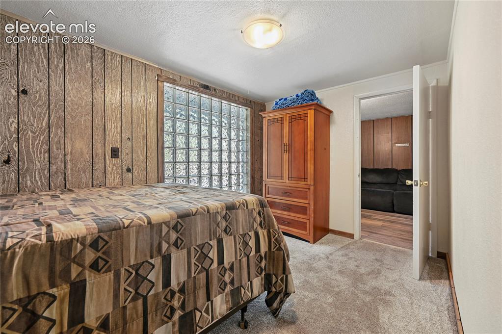 Image 16 of 50: Wood-paneled accent wall, glass block window, recessed ceiling light, and n