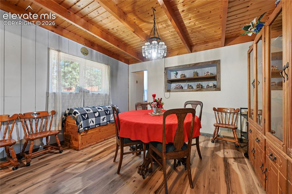Image 21 of 50: Wood-finish flooring, exposed wood beam ceiling, recessed wall shelving, an